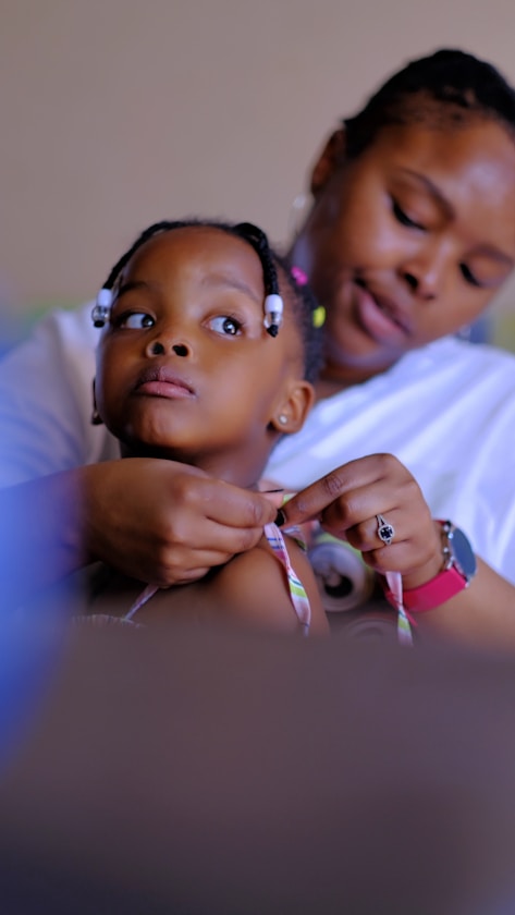 A mother adjusting her daughter's hair ribbon