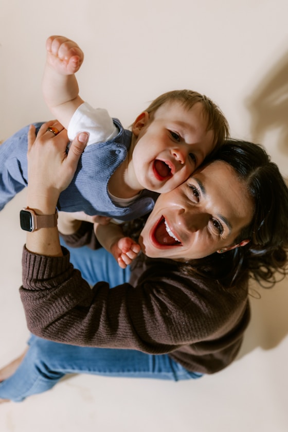 A mother laughing while holding her joyful baby