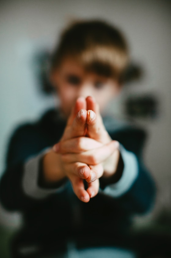 A close-up of a boy's hands clasped together