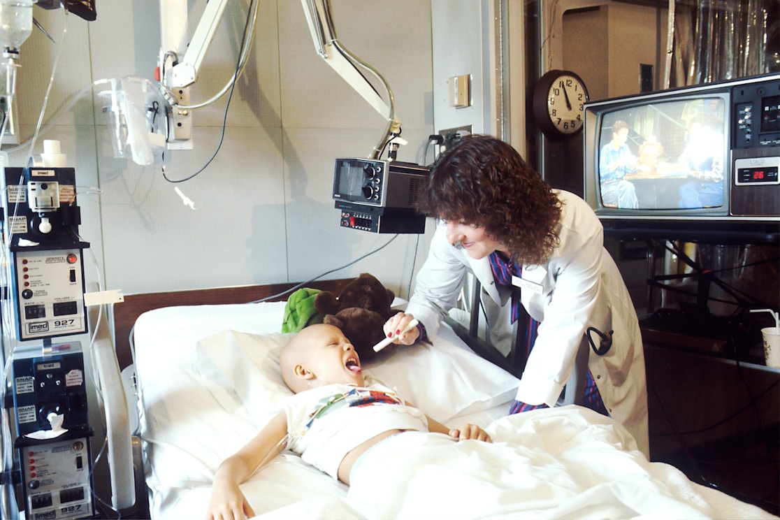 A doctor checking on a child resting in a hospital bed