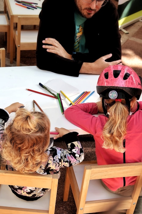 Two children drawing together at a table