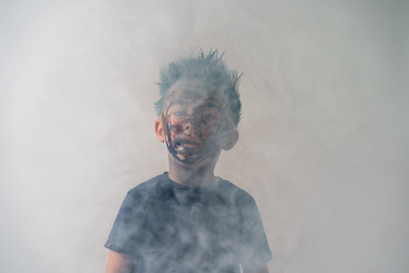 A boy's face obscured by smoke, looking distressed