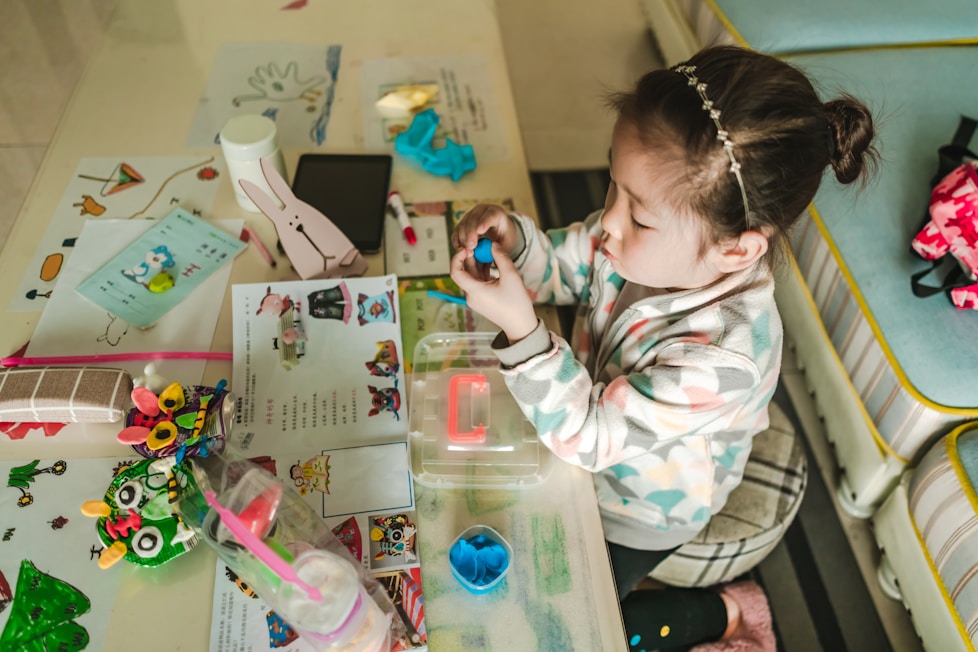 A girl playing with craft materials at a table