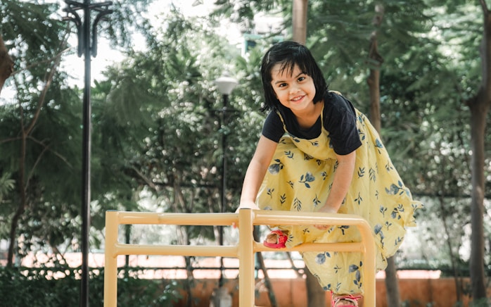 A girl climbing on playground equipment outdoors