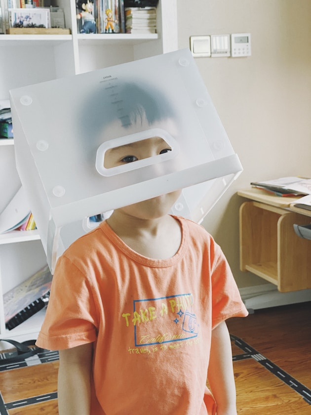 A boy wearing a box over his head as a sensory play activity