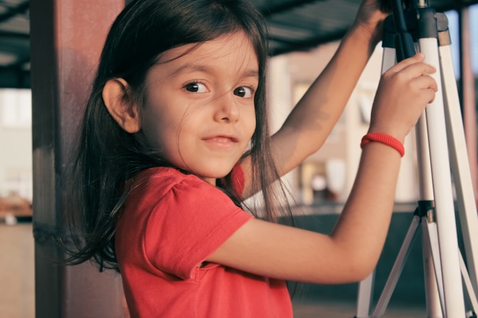 A girl reaching up towards camera equipment