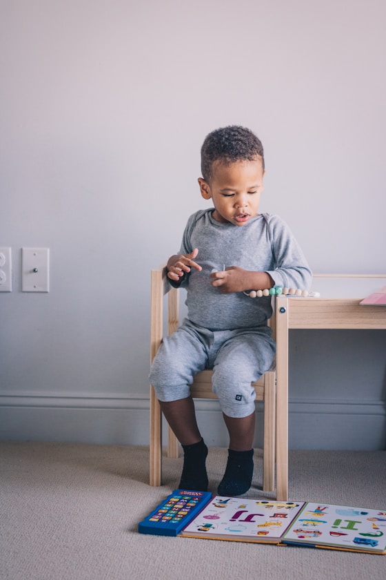 A boy sitting at a small table with an activity