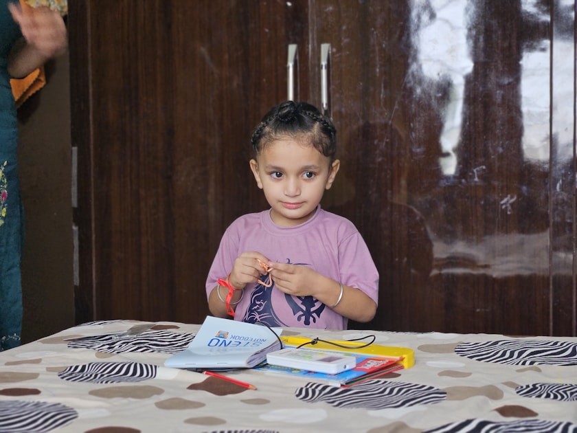 A girl sitting at a table with notebooks