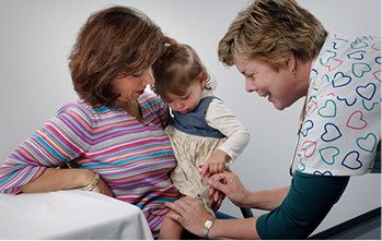 A clinician helping a toddler during an occupational therapy session