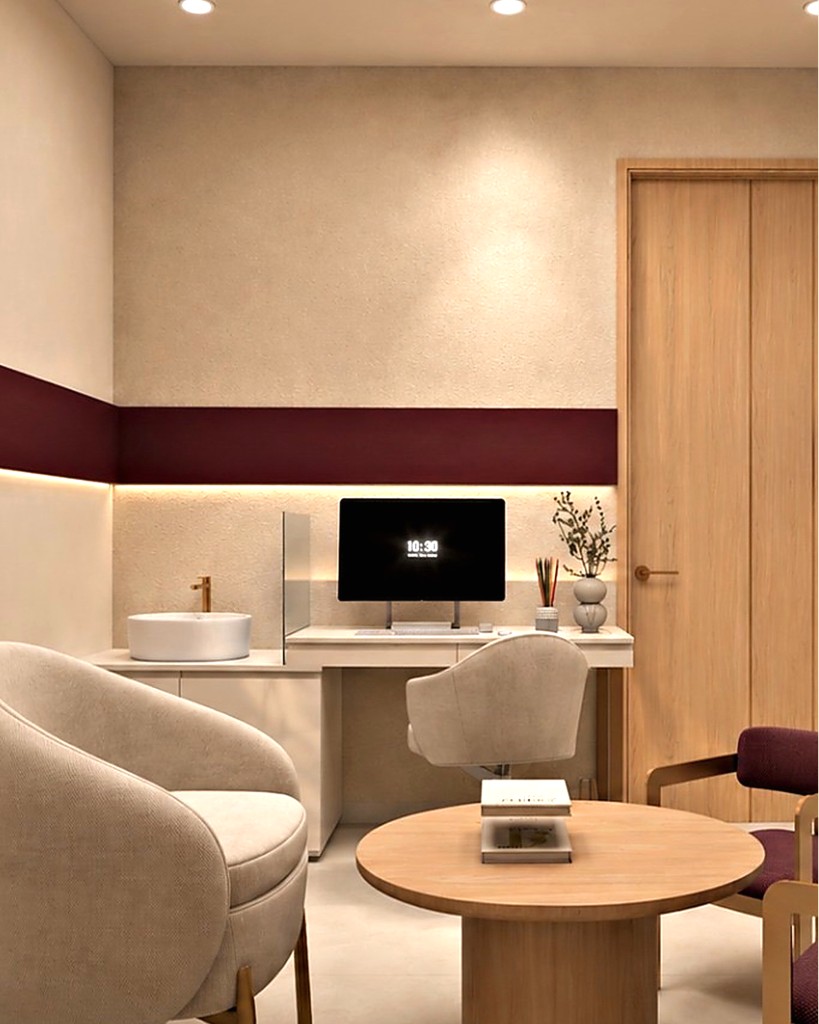 A calm consultation room with a cream armchair, desk and burgundy wall accent at Hiba by Anthalora