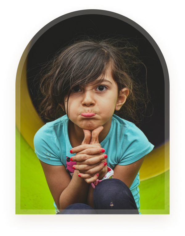 A girl sitting thoughtfully on a playground slide