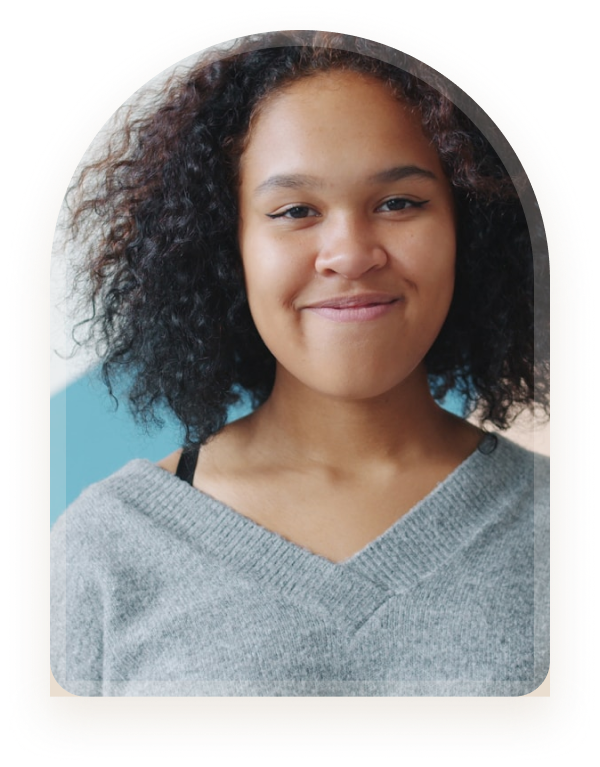 A girl with curly hair smiling warmly