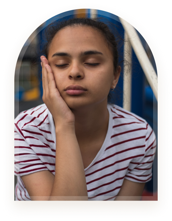 A girl resting her face against her hand with eyes closed