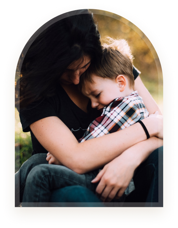 A parent comforting a young child outdoors