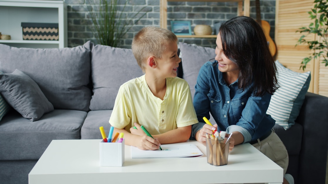 A parent and child writing together at home